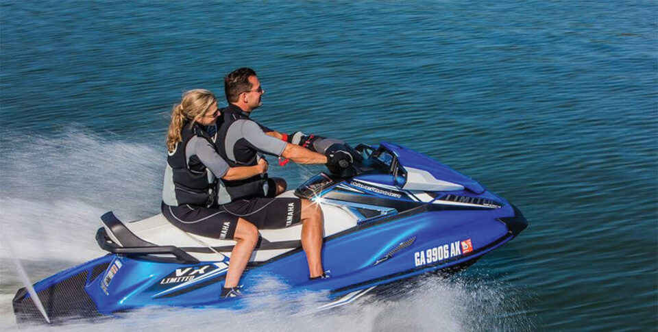 A couple riding on a jet ski out at sea.