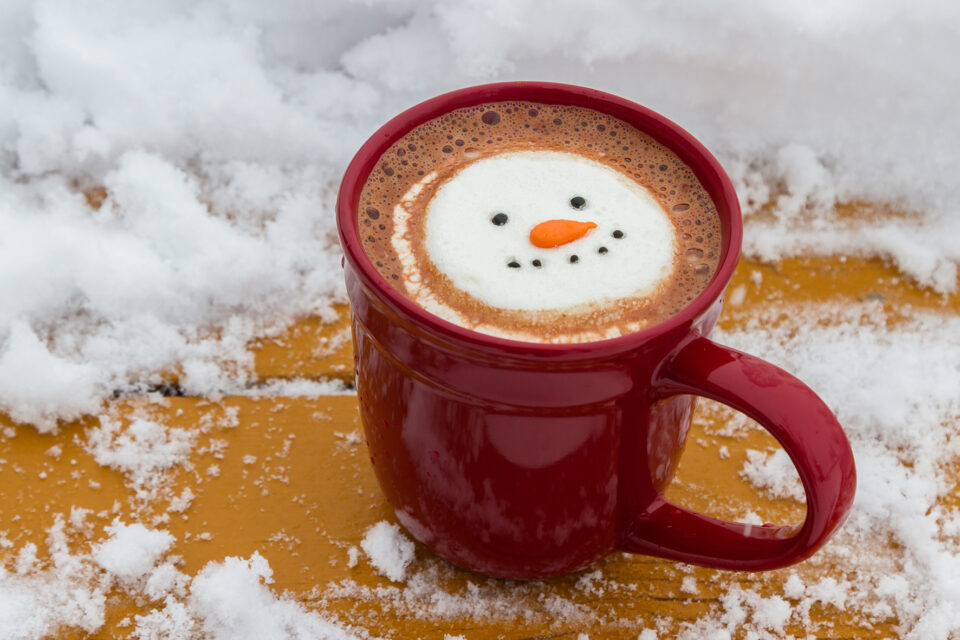 hot cocoa beverage mixed with Irish whiskey garnished with a smiling snow-person marshmallow
